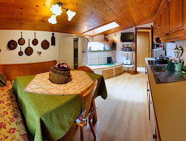 Küche mit Esstisch und einen gemütlichen Ofen