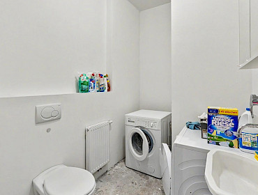 Waschraum mit Waschmaschine, Trockner und WC