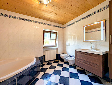 Badezimmer mit Dusche, Badewanne und Fenster