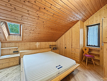 Helles Schlafzimmer mit maßgefertigtem Kleiderschrank, großem Fenster und Dachfenster