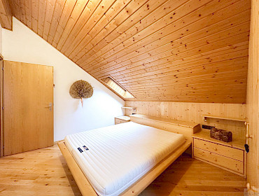 Helles Schlafzimmer mit maßgefertigtem Kleiderschrank, großem Fenster und Dachfenster